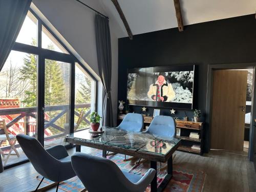 a living room with a glass table and blue chairs at Casa Larisa Antonia Apartments in Sinaia