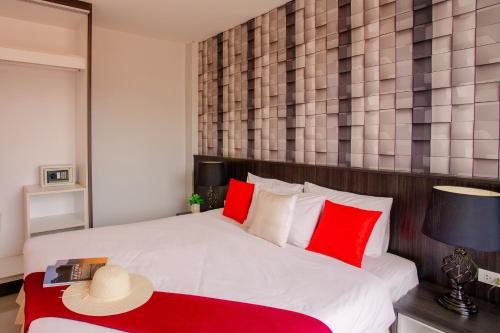 een slaapkamer met een groot wit bed met rode kussens bij The Wings Boutique Hotels Krabi Ko Lanta in Koh Lanta