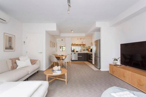 a living room with a couch and a tv and a table at Breaksea Villa Walk to The Beach in South Beach