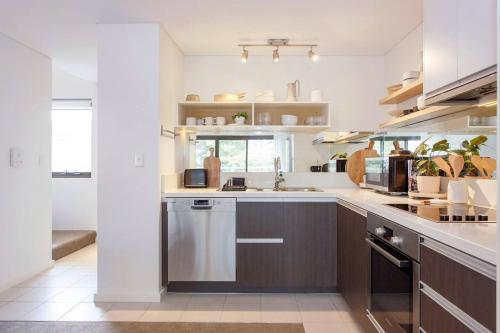 a kitchen with a sink and a dishwasher at Breaksea Villa Walk to The Beach in South Beach