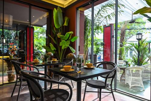 a dining room with tables and chairs on a patio at Thao Dien Village Boutique Hotel in Ho Chi Minh City