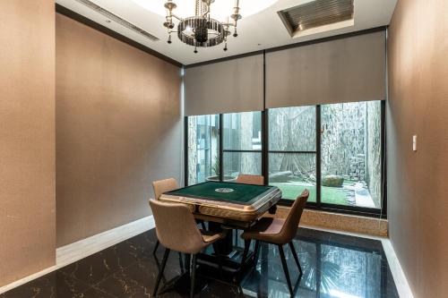 a dining room with a table and chairs and a pool at OHYA Chain Boutique Motel Taoyuan in Taoyuan