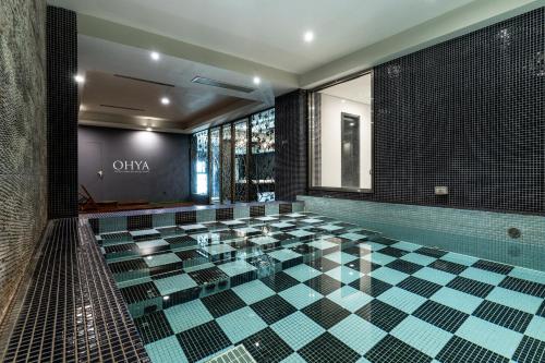 a glass pool in a bathroom with a tile floor at OHYA Chain Boutique Motel Taoyuan in Taoyuan