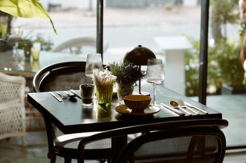 a table with plates and glasses on top of it at Thao Dien Village Boutique Hotel in Ho Chi Minh City