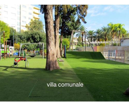 a park with a tree and a playground at Filuvespri in Comiso