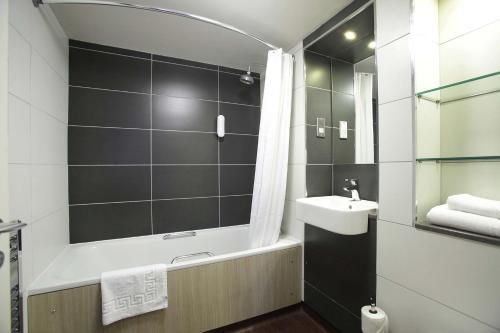 
a bathroom with a shower, sink, and toilet at The King's Highway Wetherspoon in Inverness
