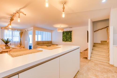 a kitchen with white cabinets and a living room at Au coeur de la Citadelle parking in Aigues-Mortes