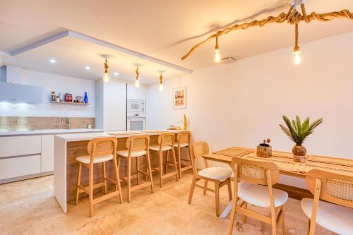 a kitchen and dining room with a wooden table and chairs at Au coeur de la Citadelle parking in Aigues-Mortes