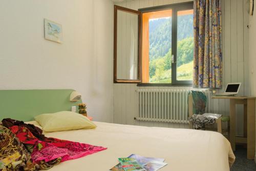 un dormitorio con una cama con ventana y una cama sidx sidx sidx en VTF Le Rafour, en Arêches