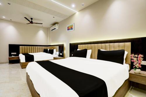 two beds in a hotel room with white and black at Collection O THE PARK LANE in Delhi
