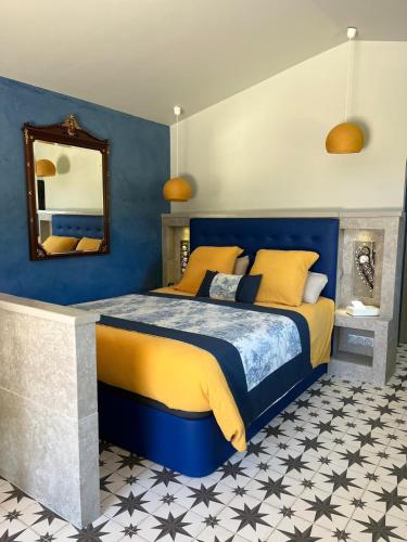 - une chambre avec un lit bleu et jaune et un miroir dans l'établissement Maisonnette climatisée, à Aix-en-Provence
