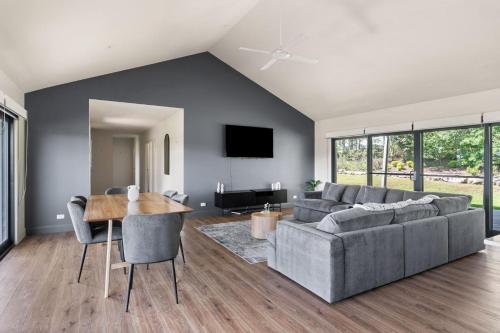 a living room with a couch and a table at Travertine Vineyard Retreat - Stay Among the Vines in Pokolbin