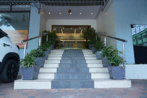 a staircase leading to a building with potted plants at The Orange Hotel in Visakhapatnam