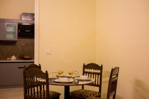 a table with chairs and wine glasses on it at Alaya Stays 3 BHK Walnuts Apartments with Gazebo in Solan