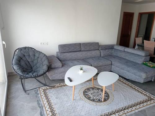 a living room with a couch and a table and a chair at Appartement entier avec Terasse, Hammam, BBQ in Alger