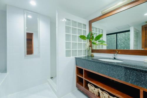 a bathroom with a sink and a mirror at The Sands 2 bedroom apartment Naiharn in Nai Harn Beach