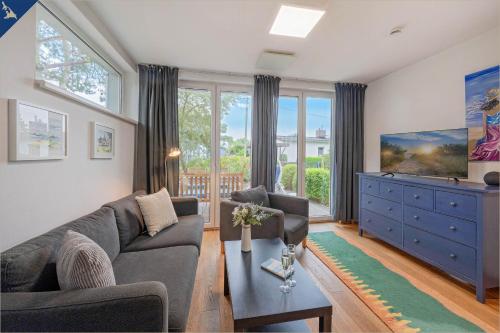 a living room with a couch and a tv at Ferienhaus am Peenestrom in Quilitz