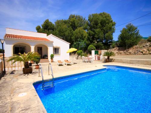 a villa with a swimming pool in front of a house at Holiday Home Caleta in Jávea