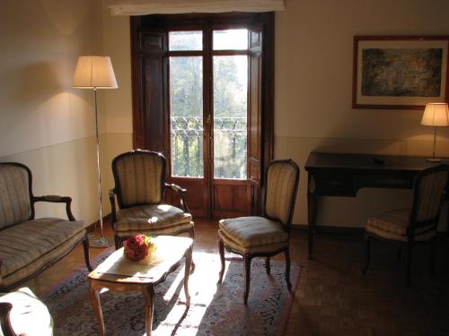 a living room with a table and chairs and a piano at Hotel Villa Quiete in Montecassiano