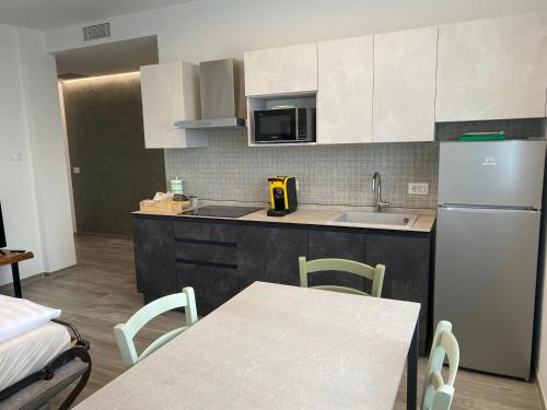 a kitchen with a sink and a refrigerator and a table at Ca’ del Riccio verde in Bra