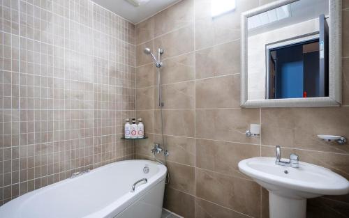 a bathroom with a sink and a bath tub and a sink at Rings Hotel in Gunsan