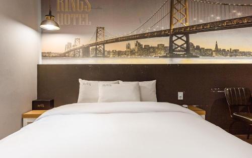 a bedroom with a large bed with a bridge on the wall at Rings Hotel in Gunsan