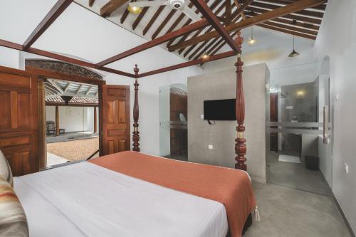 a bedroom with a bed and a television in it at Kurundu Walawwa Villas and Suites by The Clarks in Ahungalla