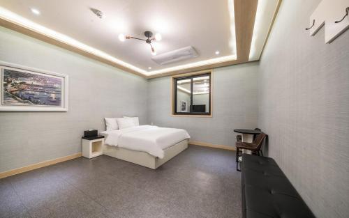a hotel room with a bed and a window at Rings Hotel in Gunsan