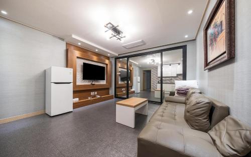 a living room with a couch and a television at Rings Hotel in Gunsan