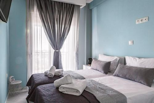 a bedroom with two beds with towels on them at Christinas apartment in Nea Moudania