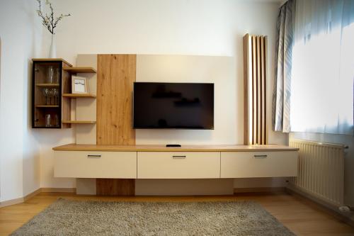 a entertainment center with a flat screen tv in a living room at Almtalhotel Appartements in Pettenbach in Pettenbach