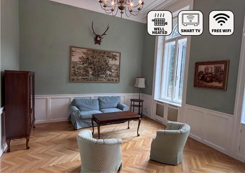 a living room with a blue couch and chairs at Herrnhof in Reichenau