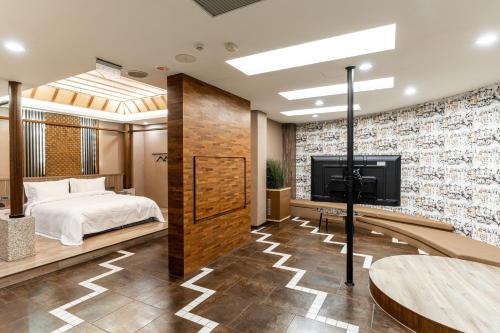 a bedroom with a bed and a flat screen tv at OHYA Chain Boutique Motel-Yongkang in Yongkang