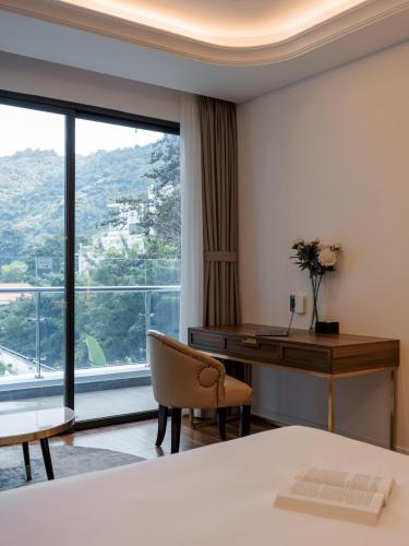 a hotel room with a desk and a window at OYSTER BAY HOTEL VUNG TAU in Vung Tau