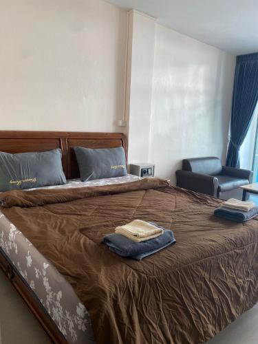 a bedroom with a bed with two towels on it at Sorot Darika Jomtien Beach in Jomtien Beach