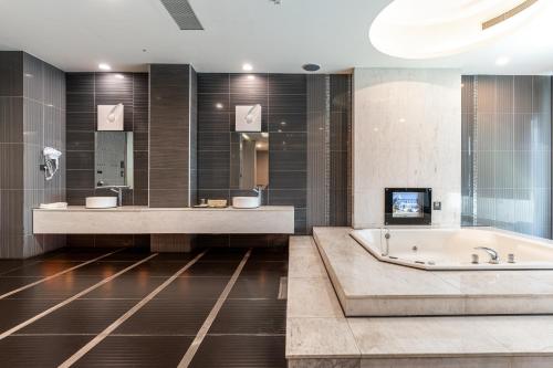 a bathroom with two sinks and a bath tub at OHYA Chain Boutique Motel-Yongkang in Yongkang