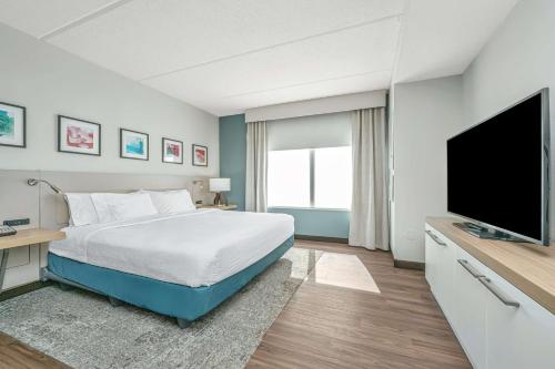 a bedroom with a bed and a flat screen tv at Hilton Garden Inn Charleston Airport in Charleston