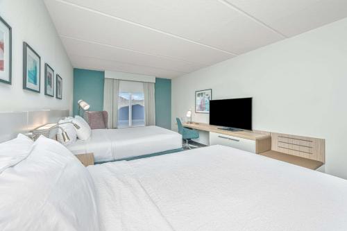 a hotel room with two beds and a flat screen tv at Hilton Garden Inn Charleston Airport in Charleston