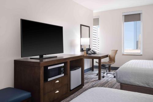 a hotel room with a flat screen tv on a desk at Hampton Inn & Suites Denver Downtown Convention Center in Denver