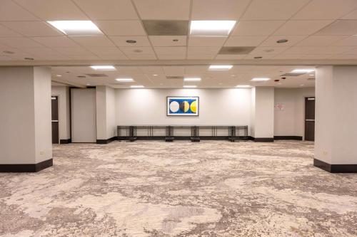 a large room with white walls and a painting on the wall at Hilton Chicago O'Hare Airport in Rosemont