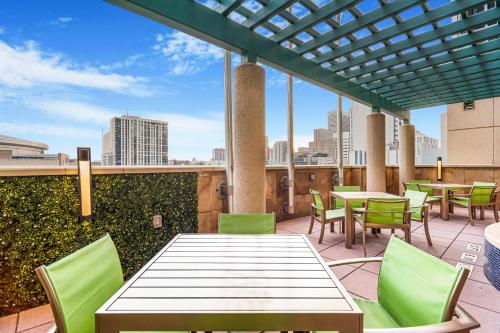 a patio with tables and chairs with a view of the city at Embassy Suites Houston - Downtown in Houston