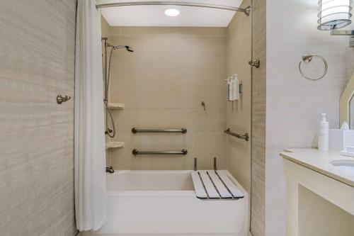 a bathroom with a bath tub and a sink at Embassy Suites Houston - Downtown in Houston