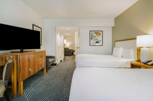 a hotel room with two beds and a flat screen tv at Embassy Suites Houston - Downtown in Houston