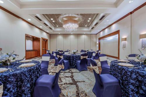 a conference room with tables and chairs and a chandelier at Embassy Suites Houston - Downtown in Houston