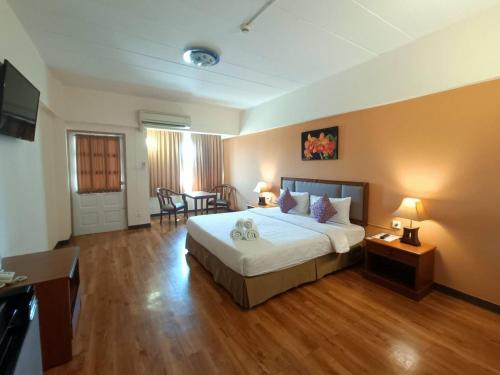 a hotel room with a bed and a table and chairs at Regent Ramkhamhaeng 22 in Bangkok
