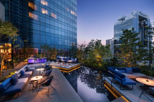a rooftop patio with tables and chairs and a building at Canopy By Hilton Osaka Umeda in Osaka