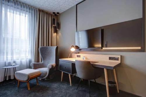 a hotel room with a desk and two chairs at Vienna House Easy by Wyndham Dortmund City in Dortmund