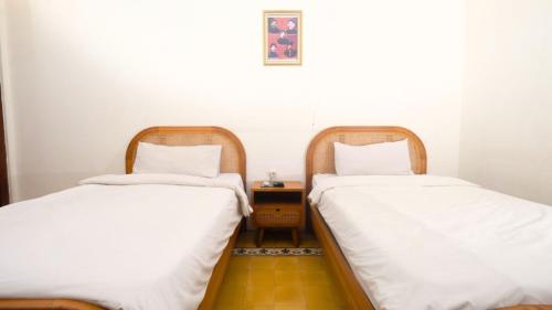 two beds sitting next to each other in a room at The Mangkoro Hotel by Sinergi in Yogyakarta