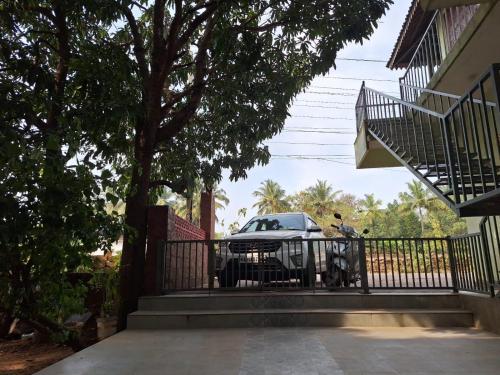 a car parked on a fence next to a house at Mangrove Ecostay in Gokarna