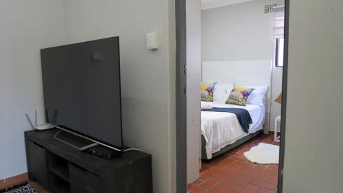 a living room with a television and a bed at Kombi Cove Blaauwberg in Cape Town